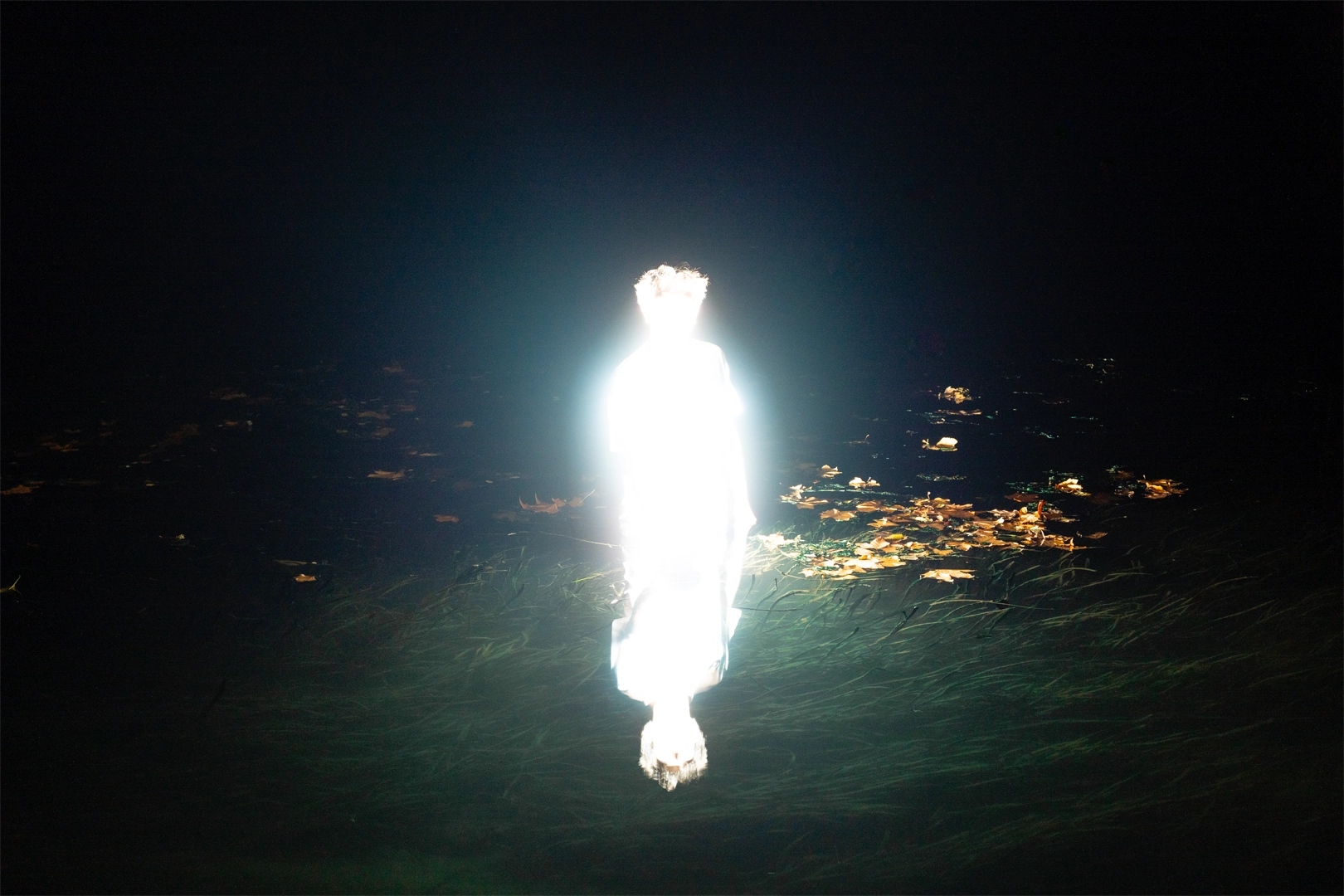 Expérimentation lumineuse d'une silhouette dans l'eau la nuit