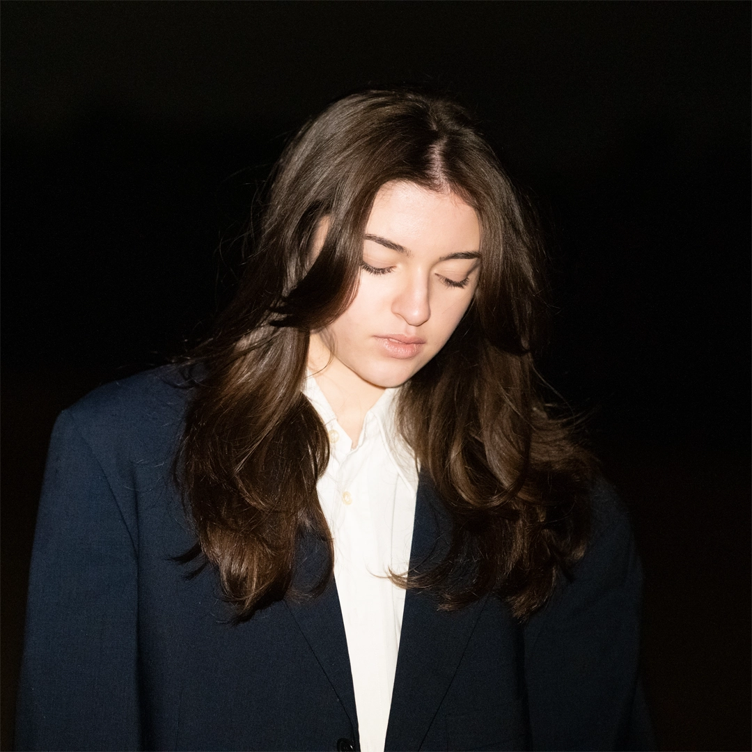 Portrait minimaliste d'une femme en veste bleue la nuit