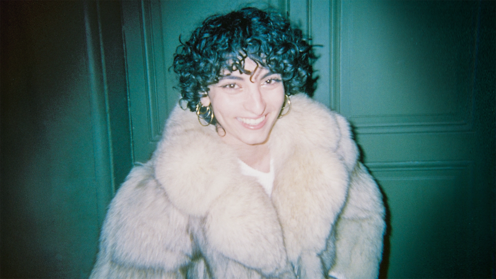 Portrait d'une femme souriante en fourrure sous un flash nocturne